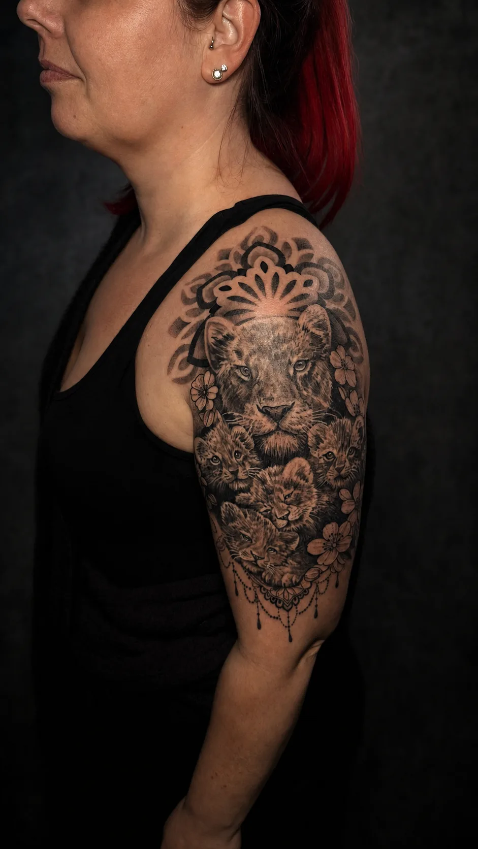 Leopardin mit Jungtieren als realistisches Oberarmtattoo